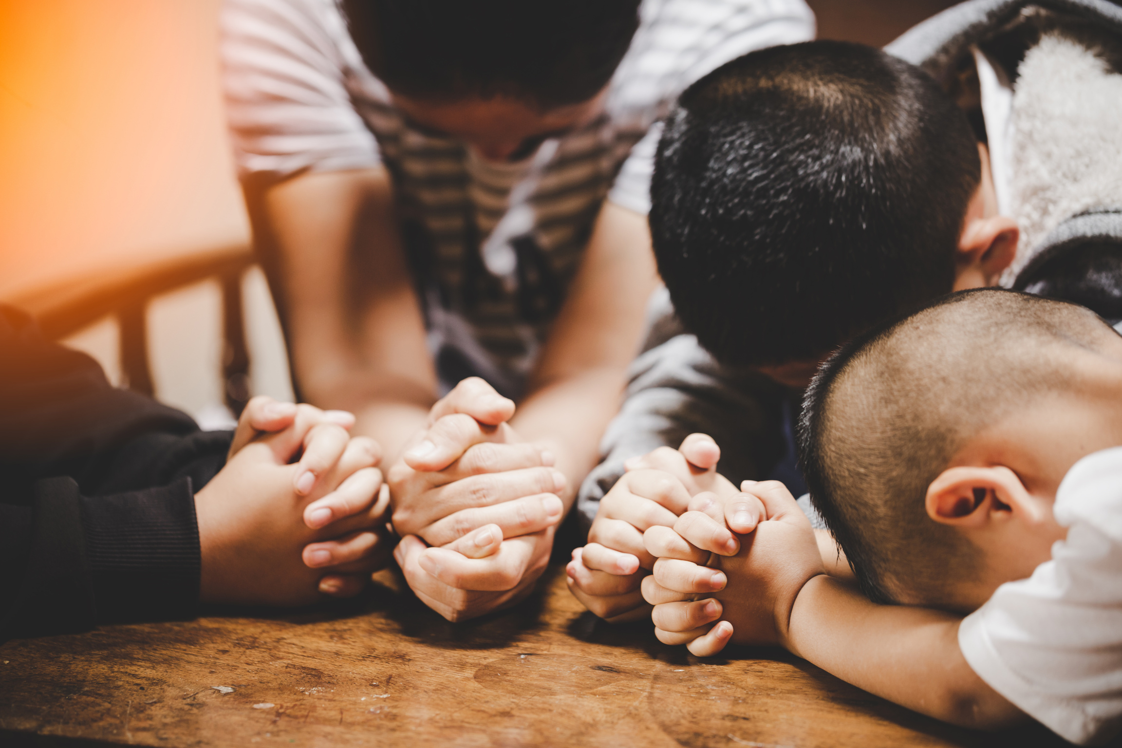 Mother and children praying and praising God at home